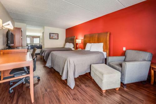 a hotel room with two beds and a desk at Econo Lodge Inn & Suites in Griffin