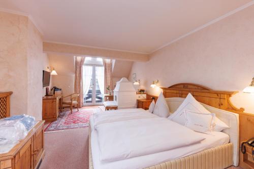 a bedroom with a large white bed and a window at Lahntalhotel Feudingen in Bad Laasphe