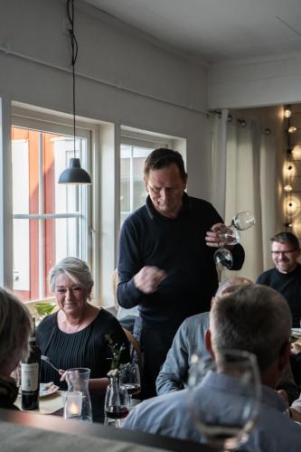 a man standing in a room with a glass of wine at Stora Frögården in Mörbylånga