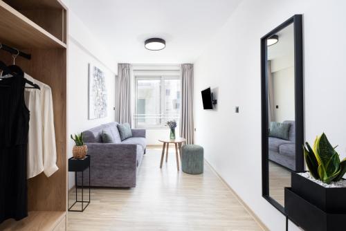 a living room with a couch and a mirror at Enattica Suites in Athens