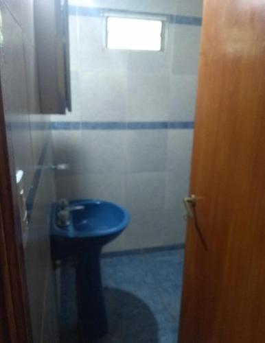 baño con aseo azul y ventana en LOS PINARES en Mar del Plata