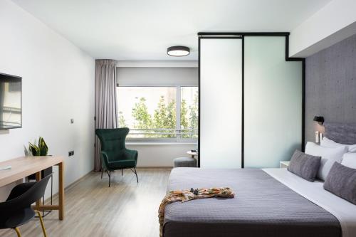 a bedroom with a bed and a desk and a chair at Enattica Suites in Athens