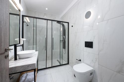 a bathroom with a shower and a toilet and a sink at Enattica Suites in Athens