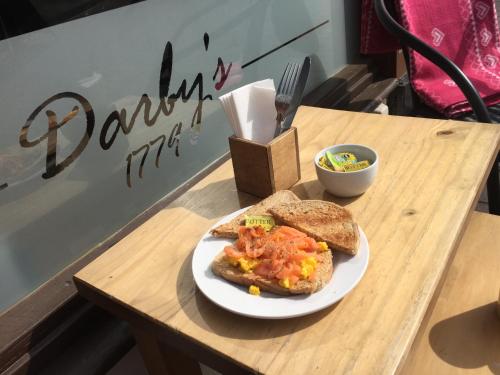 a plate of food with a sandwich and bread on a table at Bridge View Guest House in Ironbridge