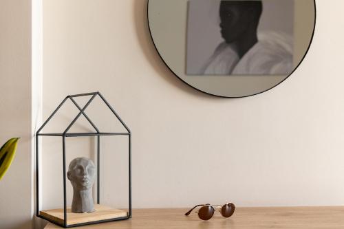 a statue in a glass box on a table with a mirror at Enattica Suites in Athens