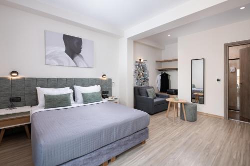 a bedroom with a bed and a desk and a chair at Enattica Suites in Athens