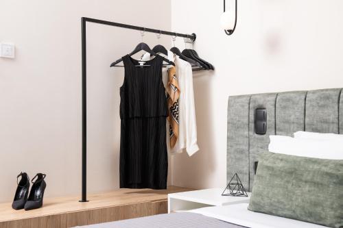 a black dress hanging on a rack in a bedroom at Enattica Suites in Athens
