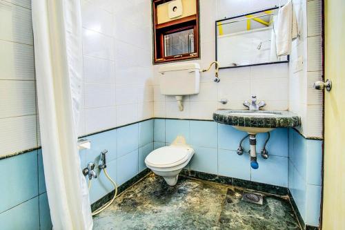 a bathroom with a toilet and a sink at Kokanwadi Resort in Ratnagiri