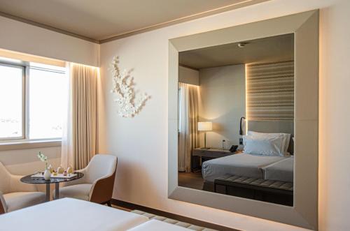 a bedroom with a bed and a mirror at EPIC SANA Marquês Hotel in Lisbon