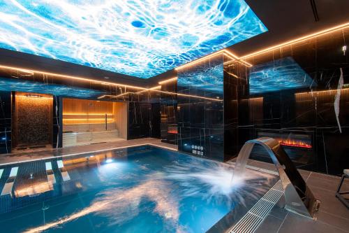 EPIC SANA Marquês Hotel في لشبونة: حمام سباحة في غرفة مع سقف مليء بالضوء