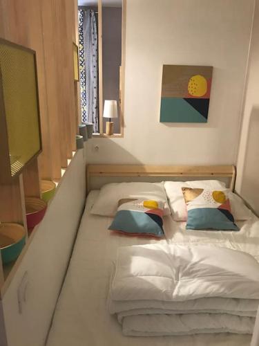 a large white bed with pillows on it at Milly COCOON / centre ville in Milly-la-Forêt