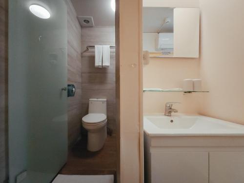 a bathroom with a toilet and a sink at Taipei Inn in Taipei