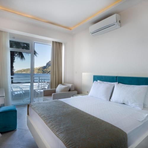 a bedroom with a bed and a view of the ocean at Hotel Mavi Deniz in Turunç