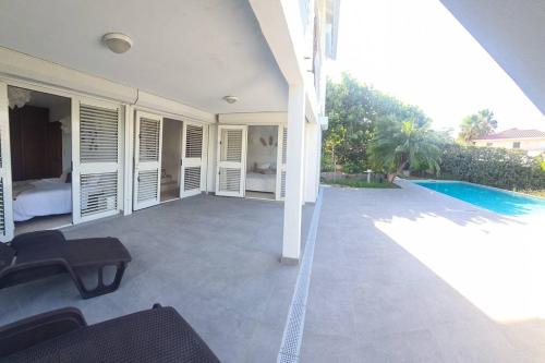 a patio with a bed and a swimming pool at Villa Picaflor, Friar's Bay in Friar's Bay