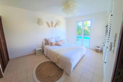 聖馬丁島的住宿－Villa Picaflor, Friar's Bay，白色的卧室设有床和大窗户