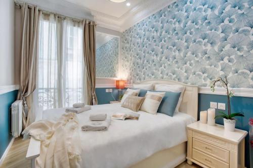 - une chambre avec un grand lit blanc et un mur bleu dans l'établissement Elégant 120m2 3CH quartier Romantique Centre Ville, à Paris