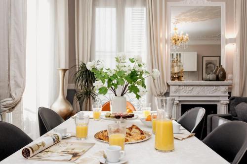 - une table à manger avec de la nourriture et du jus d'orange dans l'établissement Elégant 120m2 3CH quartier Romantique Centre Ville, à Paris
