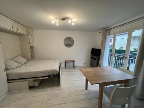 a small bedroom with a bed and a table and a tableablish at Naïades 2 in La Baule
