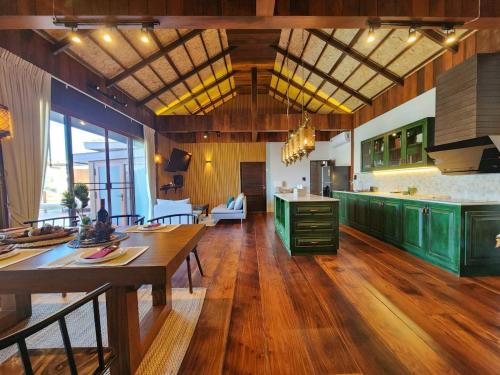 eine große Küche mit Holzböden und grünen Schränken in der Unterkunft Grand Kokkod Khao Kho Resort in Khao Kho