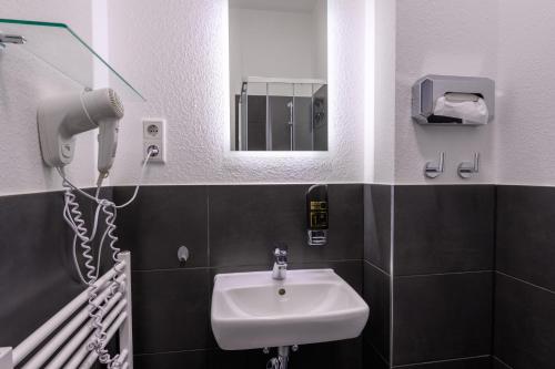 a bathroom with a sink and a mirror at Royale Apartaments Central City Cologne in Cologne