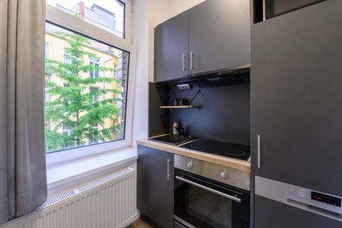 a kitchen with a stove top oven next to a window at Royale Apartaments Central City Cologne in Cologne