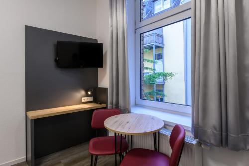 a room with a table and chairs and a window at Royale Apartaments Central City Cologne in Cologne
