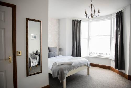 a bedroom with a bed and a mirror and a window at The George Hotel in Kirton in Lindsey