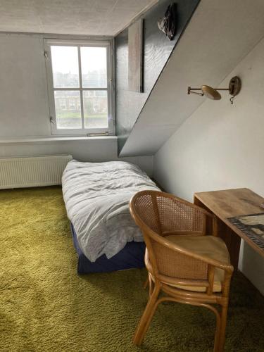 Luc's place, Waterbed grote kamer في Zoeterwoude: غرفة نوم بسرير ومكتب وكرسي