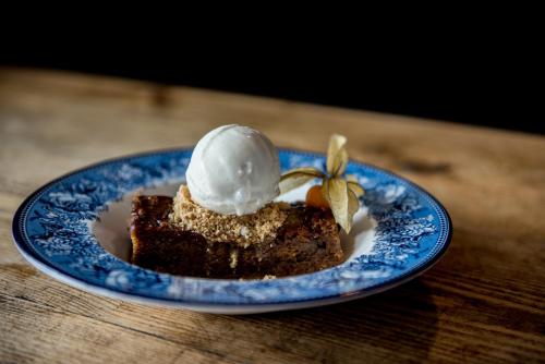 a piece of cake with ice cream on a blue plate at The George Hotel in Kirton in Lindsey