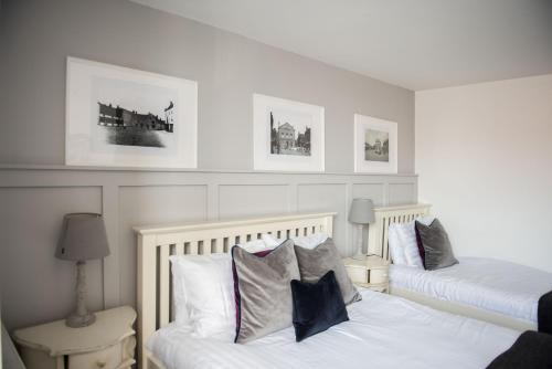 a bedroom with two beds and two pictures on the wall at The George Hotel in Kirton in Lindsey