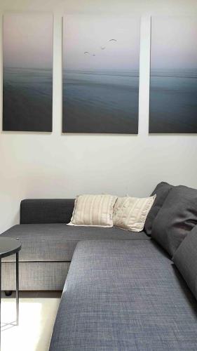 un salon avec trois photos sur le mur dans l'établissement le meublé du pêcheur, à Port-Saint-Louis-du-Rhône