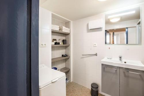 een witte badkamer met een wastafel en een toilet bij Maison atypique dans circulade in Bram