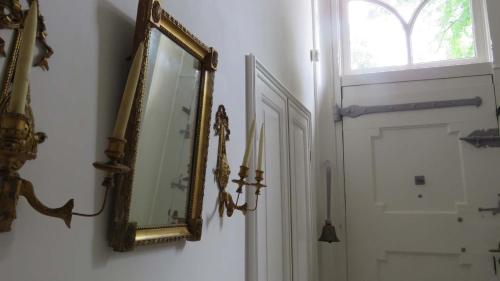 a mirror hanging on a wall next to a door at B&B Monumentaal Logeren in Zierikzee