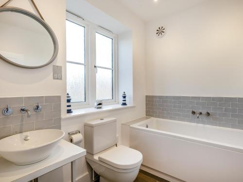 a bathroom with a toilet and a sink and a mirror at Schaels Retreat in Binham