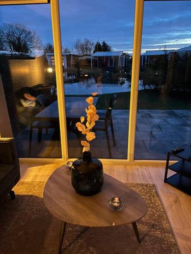 a vase on a table in a living room at Luxus Chalet Waterfront in Lathum