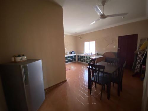 a kitchen and dining room with a table and chairs at Homestay Kimanis Papar in Kimanis