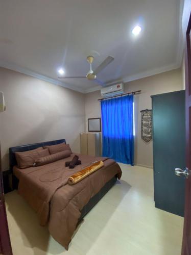 a bedroom with a large bed with a blue curtain at Homestay Kimanis Papar in Kimanis