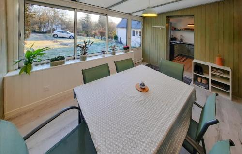 une salle à manger avec une table et des chaises et une fenêtre dans l'établissement Gorgeous Home In Moëlan-Sur-Mer, à Moëlan-sur-Mer