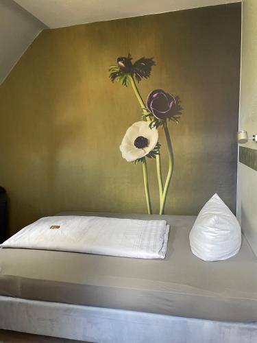 a bed with a vase of flowers on the wall at Badischer Hof in Bühl