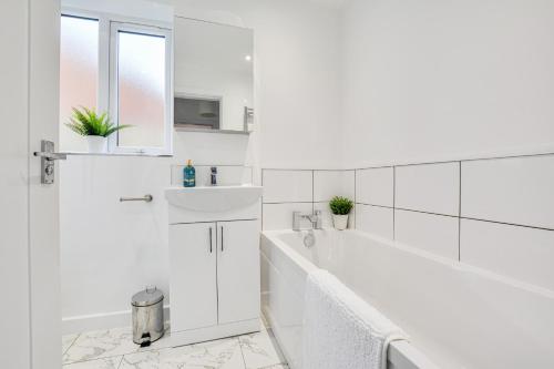 biała łazienka z wanną i umywalką w obiekcie Luxury 3-Bedroom House In Formby w mieście Formby