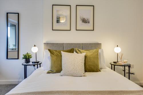 um quarto com uma cama branca e almofadas verdes em Luxury 3-Bedroom House In Formby em Formby