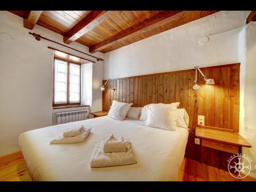 a bedroom with a large white bed with two towels on it at Casa Pins de Alma de Nieve in Baqueira-Beret