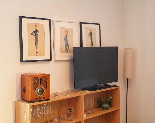 a tv and a speaker on a shelf with pictures at Apartment Ida in Berlin