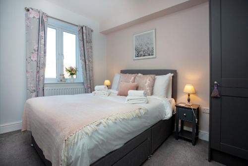 a bedroom with a large bed with two towels on it at Shell Cottage in Sidmouth