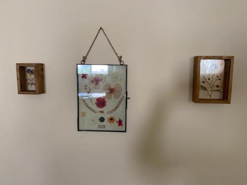 a clock hanging on a wall next to two pictures at O&B Hospitality - אירוח אלף בית in Metsudat Menahem Ussishkin Alef