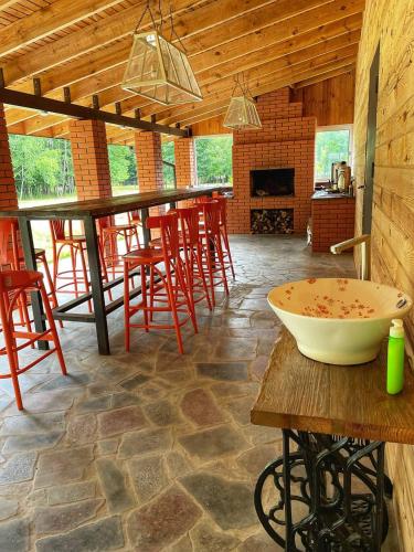 um quarto com um bar com cadeiras vermelhas e uma tigela numa mesa em Садиба Бабина Лоза em Lisove