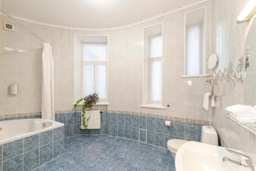 La salle de bains est pourvue d'une baignoire, d'un lavabo et de toilettes. dans l'établissement Bearsleys Archers Apartments, à Riga