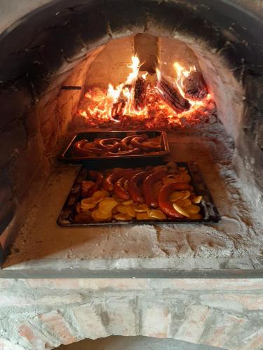 a brick oven with two trays of food in it at Varga Vendégház in Tótszerdahely