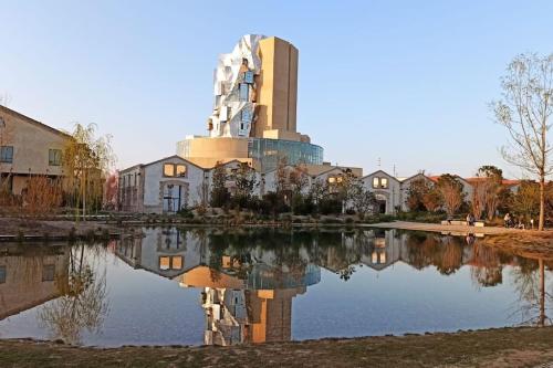 un edificio con riflessione in un lago di L' Appart du Centre Historique Charme et confort a Arles