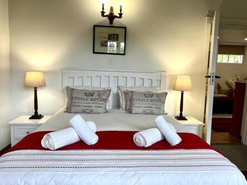 a white bed with two pillows and two lamps at Woodcroft in Lidgetton